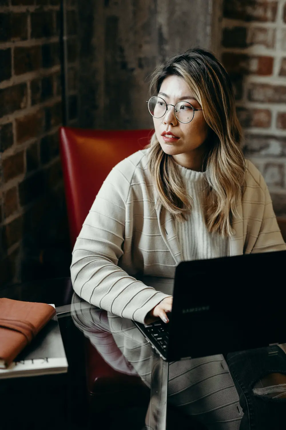 Woman on laptop looking right.